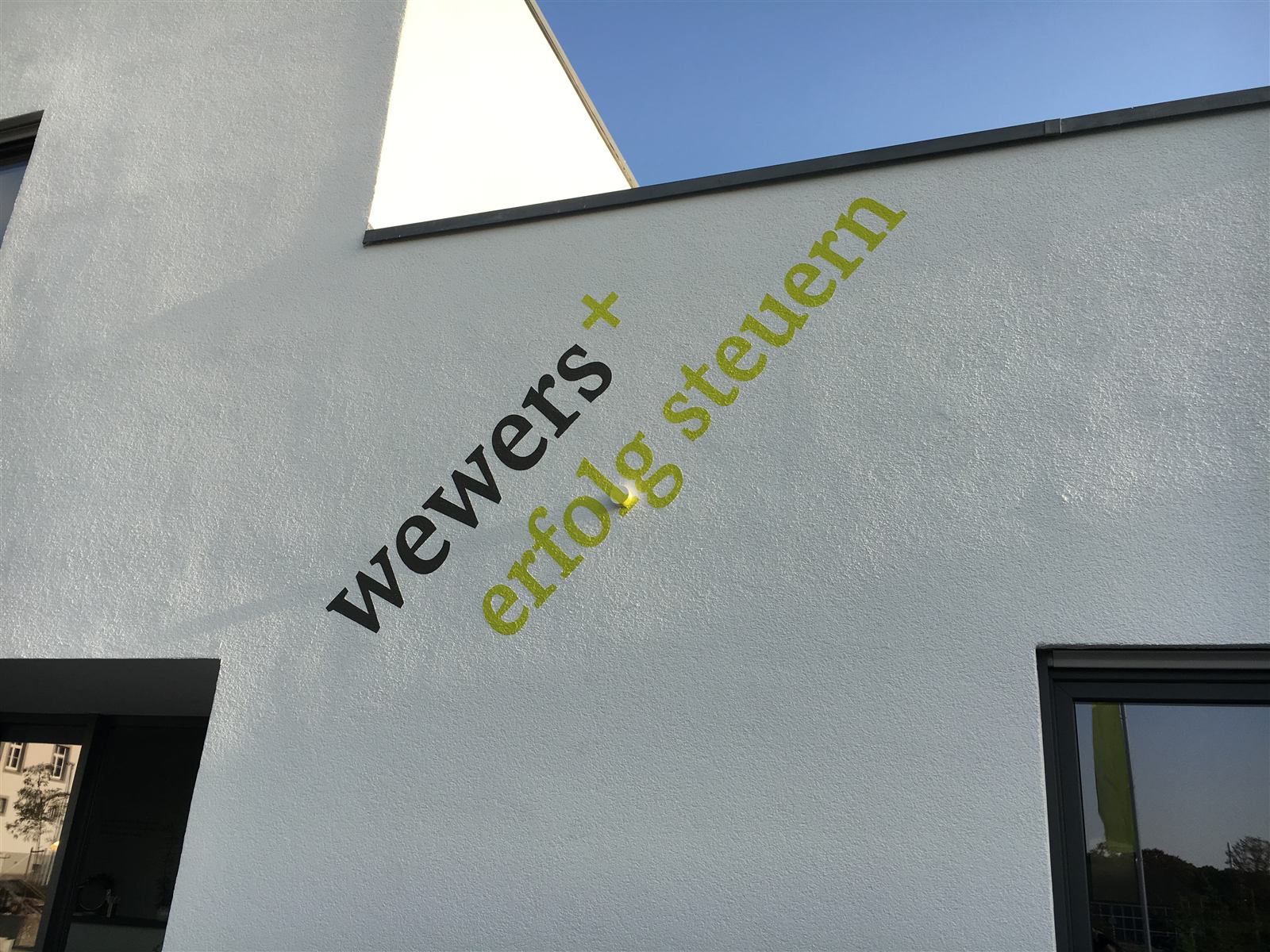 Fassadenbeschriftung mit Firmenlogo an einem Bürogebäude