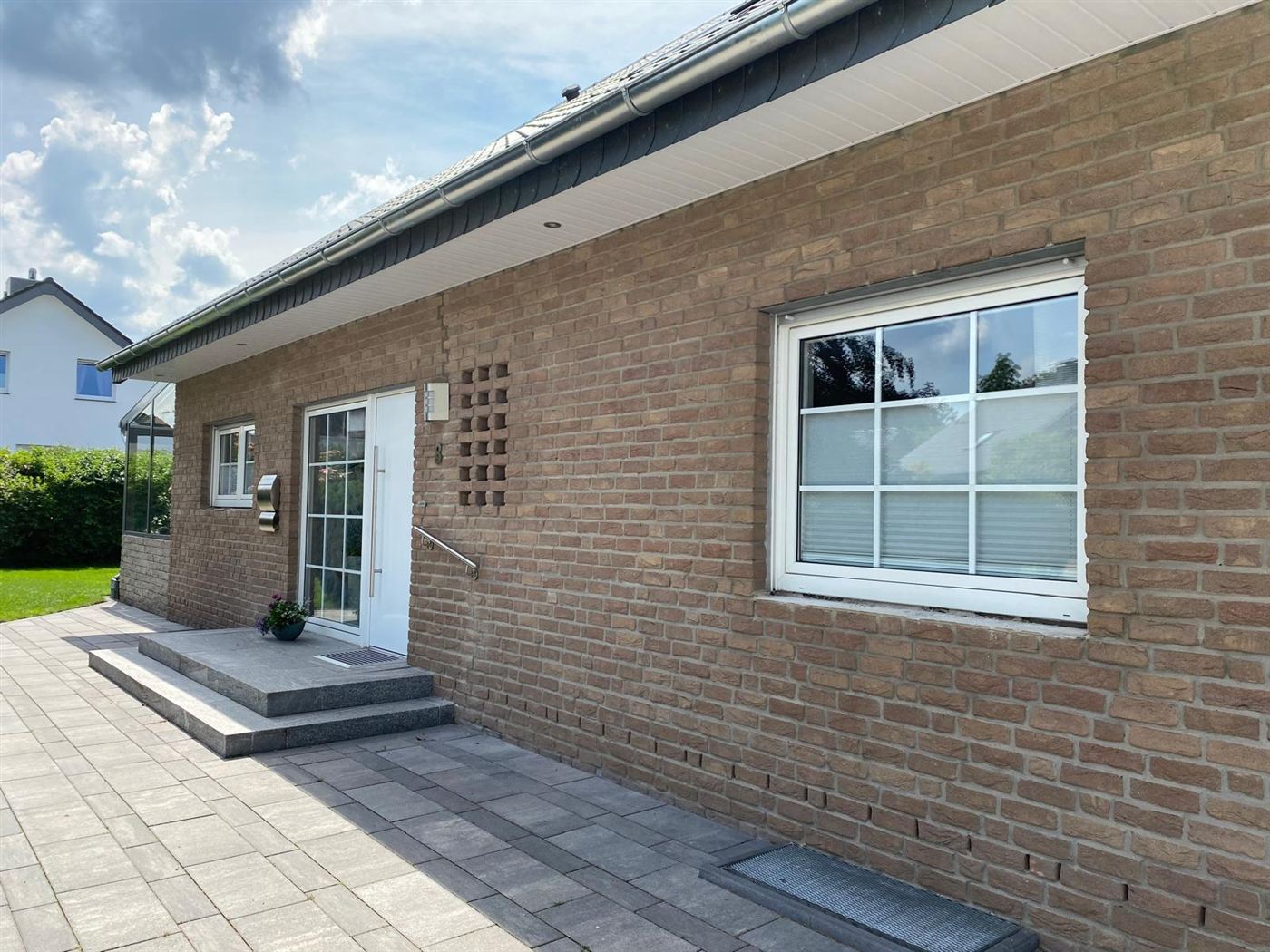 Einfamilienhaus mit brauner Klinkerfassade vor dem Anstrich